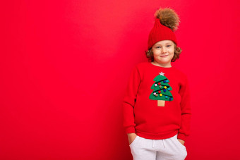快乐的有趣的男孩红色的背景温<strong>暖</strong>的他毛衣<strong>圣诞节</strong>树