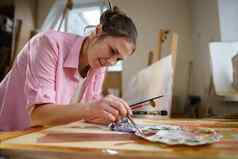 可爱的女人油漆帆布艺术车间艺术家创建图片艺术学校工作室工作油漆刷画架爱好休闲概念女人画家工作空间