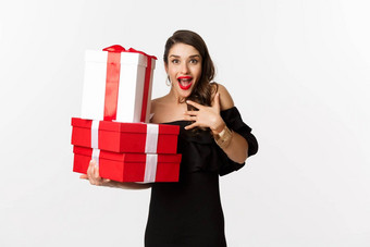 庆祝活动圣诞节假期概念兴奋快乐女人收到礼物持有圣诞节礼物欢乐站黑色的衣服白色背景