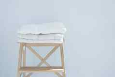 堆栈清洁浴毛巾色彩斑斓的棉花特里纺织堆放木椅子白色墙桩概念特写镜头