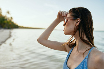 女人穿太阳镜蓝色的泳衣岛海滩太阳