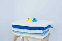 堆栈清洁浴毛巾色彩斑斓的棉花特里纺织品堆放木椅子白色墙La2概念关闭国家风格孩子们的橡胶浴玩具