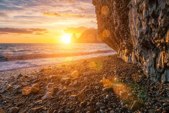 明亮的海日落波崩溃岩石基斯温暖的日落沙子鹅卵石火山玄武岩冰岛海波休息时间溅白色泡沫永无止境的美自然