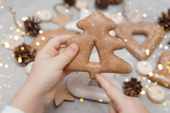 孩子们的手持有姜饼形状圣诞节树概念圣诞节糖果玩具花环散景装饰一年假期