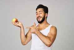 男人。白色t恤苹果手水果健康的食物光背景