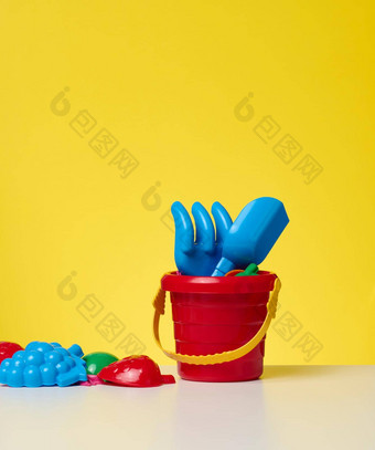 婴儿红色的<strong>塑料桶</strong>铲玩具黄色的背景