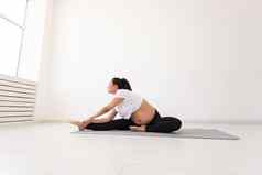 有目的的怀孕了女人练习瑜伽类放松坐着席地板上概念物理精神准备身体分娩的地方文本