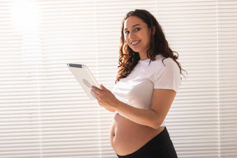 快乐怀孕了年轻的美丽的女人会说话的丈夫<strong>视频</strong>连接平板电脑概念沟通积极的的态度怀孕