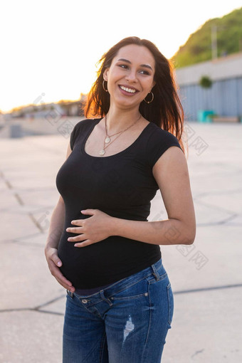 肖像拉美裔怀孕了女人走路堤日落怀孕母亲概念