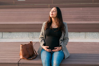 活跃的怀孕概念快乐年轻的业务学生怀孕了女人坐着板凳上未来妈妈工作研究晚些时候怀孕期