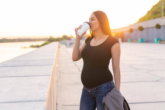 拉美裔怀孕了女人喝咖啡在<strong>户外广告</strong>区域工作空间