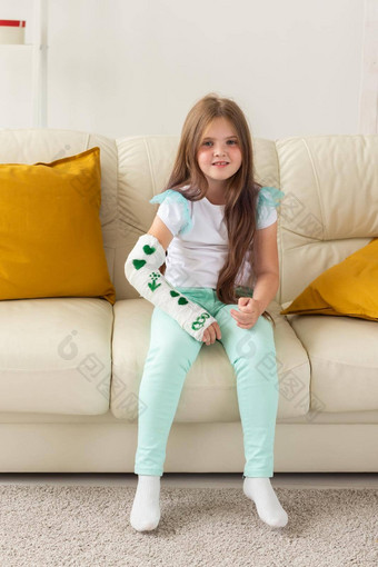 孩子投破碎的手腕手臂微笑有趣的沙发上积极的的态度复苏孩子概念