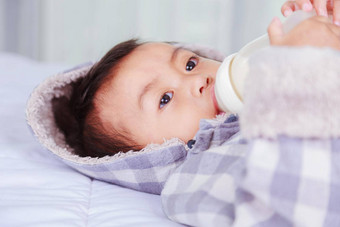 婴儿喝牛奶瓶床上