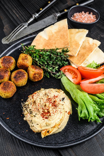 阿拉伯语厨房鹰嘴豆泥鹰嘴豆沙拉三明治丝带面包新鲜的蔬菜黑色的木背景前视图