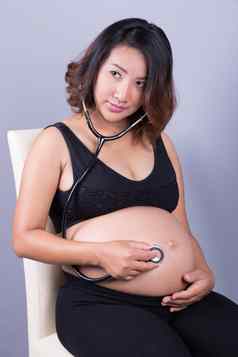 年轻的怀孕了亚洲女人听诊器听肚子婴儿