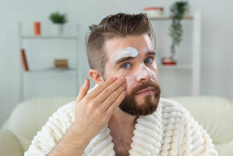 有胡子的的家伙应用<strong>抗皱</strong>奶油脸皮肤护理水疗中心男人。概念