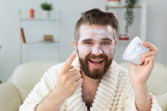 有胡子的的家伙应用抗皱奶油脸皮肤护理水疗中心男人。概念