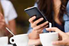 年轻的女孩手现代智能手机设备咖啡馆酒吧