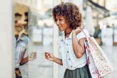 年轻的黑色的女人非洲式发型发型商店窗口