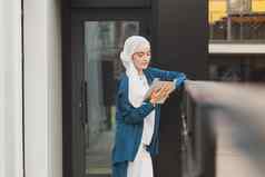 肖像阿拉伯学生女孩持有平板电脑阿拉伯业务女人戴持有平板电脑街女人穿着戴