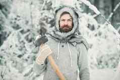 冬天有胡子的男人。伐木工人持有斧雪冬天森林