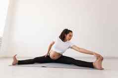 有目的的怀孕了女人练习瑜伽类放松坐着席地板上概念物理精神准备身体分娩的地方文本