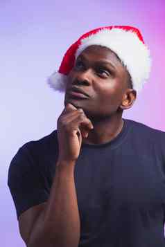 肖像沉思的非洲美国男人。圣诞老人他休闲t恤色彩鲜艳的背景圣诞节时间冬天假期情感人概念
