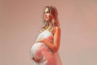优雅的怀孕了年轻的女人站穿光织物怀孕幻想仙女演讲概念