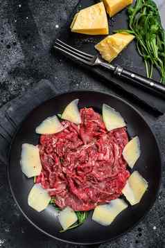 Carpaccio沙拉大理石的牛肉肉芝麻菜帕尔玛黑色的背景前视图