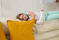 孩子投破碎的手腕手臂微笑有趣的沙发上积极的的态度复苏孩子概念