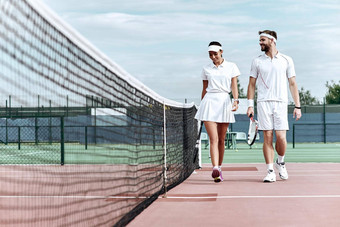 享受支出时间法院美丽的年轻的<strong>夫妇</strong>走网球法院微笑