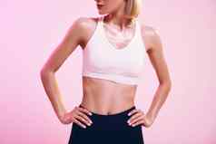 完美裁剪照片运动苗条的女人理想的身体运动服装站粉红色的背景工作室