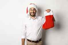 快乐圣诞节假期概念兴奋有胡子的的家伙圣诞老人他持有圣诞节袜子微笑庆祝一年白色背景