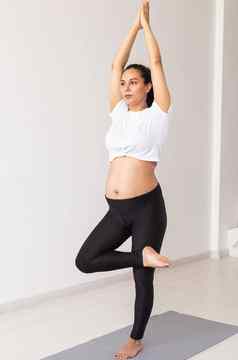 可爱的灵活的怀孕了女人体操地毯地板上白色背景概念准备身体健康的分娩
