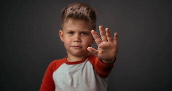 男孩红色的衬衫不开心显示停止手孤立的灰色背景人类情绪面部表达式概念面部表达式情绪感情