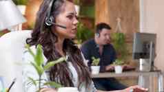 年轻的支持客户女人会说话的耳机麦克风调用中心客户