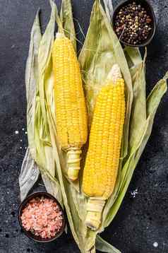 煮熟的玉米玉米穗轴盐胡椒黑色的背景前视图