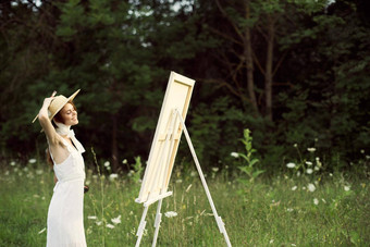 快乐的女人在户外画艺术景观爱好