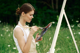 快乐的女人艺术家绘画<strong>图片</strong>在户外有创意的艺术