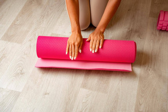 年轻的女人长头发健身教练米色运动服装伸展运动普拉提瑜伽席健身房女健身瑜伽例程概念健康的生活方式和谐冥想