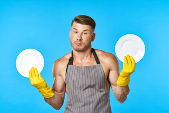 快乐的男人。围裙洗菜做家务蓝色的背景