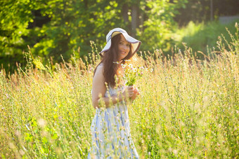 年轻的女人走野花阳光明媚的夏天一天概念快乐沟通夏天自然