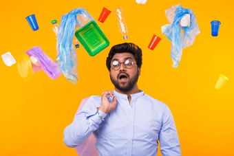 问题垃圾塑料回收污染环境概念惊讶男人。携带垃圾袋黄色的背景