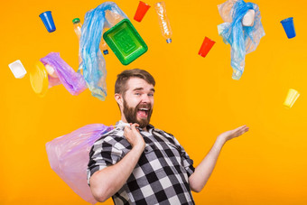 问题垃圾塑料回收污染环境概念有趣的男人。持有垃圾回收黄色的背景