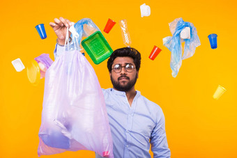 问题垃圾塑料回收污染环境概念男人。携带垃圾袋黄色的背景