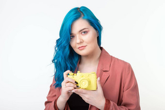 人爱好利益概念美丽的女孩蓝色的头发持有黄色的复古的相机白色背景
