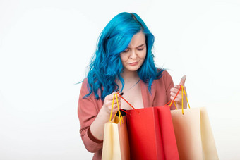 出售购物狂消费者概念美丽的女孩蓝色的头发站购物袋白色背景