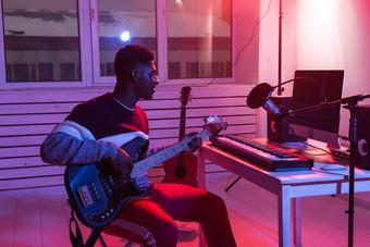 创建音乐记录工作室概念非洲美国男人。吉他手记录电低音吉他跟踪首页工作室