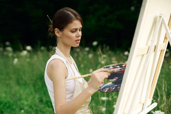 快乐的女人艺术家绘画图片在户外有创意的艺术