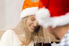 年轻的夫妇圣诞老人帽子喝酒庆祝圣诞节